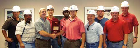 Travelers Tim McGrath, third from left, marks White Rock Quarries safety record with Alfredo Martinez, left, Hector Barrios, Nick Rudanovich, Nate Malone, Juni Tennant, Ronnie Vanlandingham, Matt Thompson, JR Payne, and Vecellio Group V.P. Safety John West. (Photo by Dave Kibby)