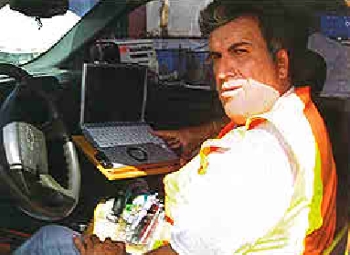 A foreman enters daily job data on a laptop computer instead of filling out paper forms as part of a new field reporting system.