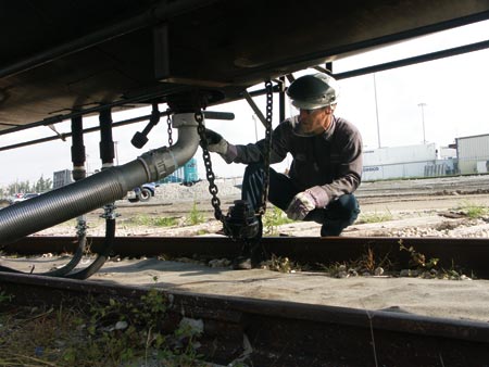 Rusty Ewell checks the connection of an asphalt railcar at South Florida Materials in the Port of Palm Beach. (Photo by Carl Thiemann)