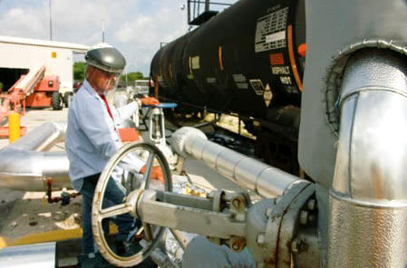 A technician with the equipment contractor bleeds air out of the lines before the first railcar shipment is unloaded. (Photo by Carl Thiemann)